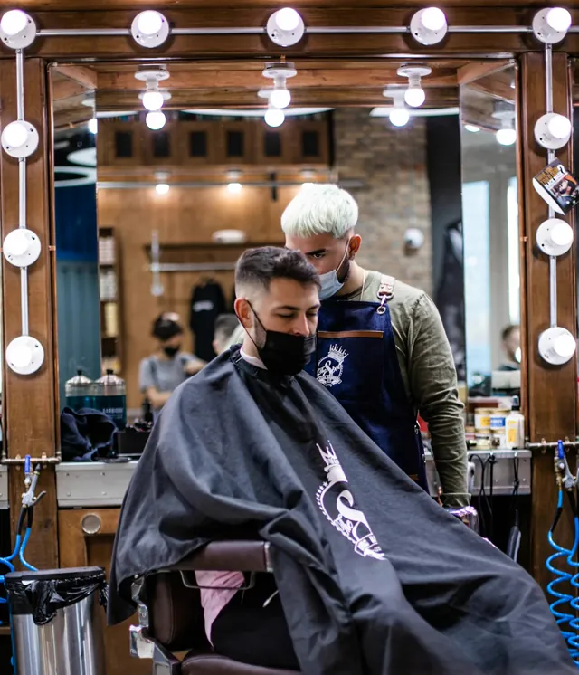 Il cliente riflesso nello specchio del barbershop