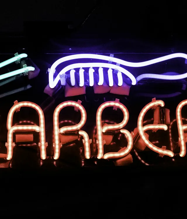 Insegna del barbershop illuminata nella notte